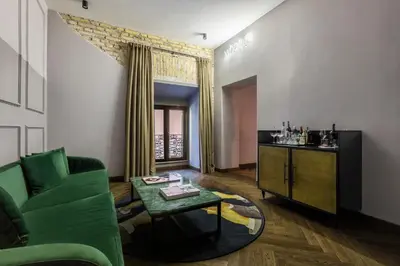 a living room with a green couch and a table at Chapter Roma in Rome