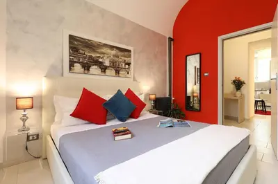 a bedroom with a bed with red and blue pillows at Grand Tour Rome Apartment - Liberty Collection in Rome