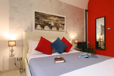 a bedroom with a bed with red and blue pillows at Grand Tour Rome Apartment - Liberty Collection in Rome