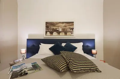 a bedroom with a bed with two pillows on it at Grand Tour Rome Apartment - Liberty Collection in Rome