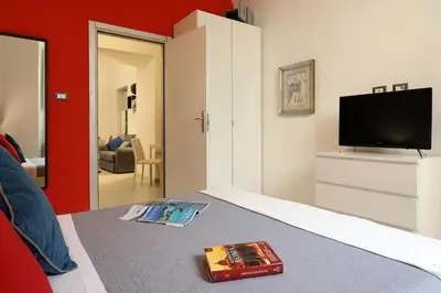a bedroom with a bed with a tv and a book at Grand Tour Rome Apartment - Liberty Collection in Rome