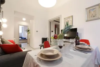 a dining room table with a white table cloth and wine glasses at Grand Tour Rome Apartment - Liberty Collection in Rome