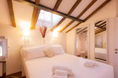 a bedroom with a white bed with two towels on it at Home D'elite Navona in Rome