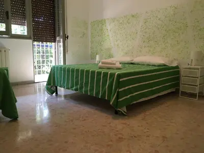 a bedroom with a green bed with two towels on it at Next Stop Roma Affittacamere Da Florindo in Rome