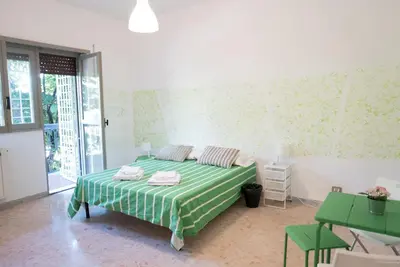 a bedroom with a bed with green and white sheets at Next Stop Roma Affittacamere Da Florindo in Rome