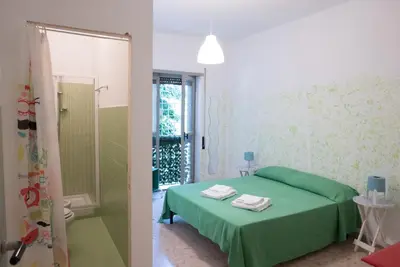 a bedroom with a green bed and a shower at Next Stop Roma Affittacamere Da Florindo in Rome
