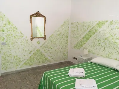 a bedroom with a green and white bed and a mirror at Next Stop Roma Affittacamere Da Florindo in Rome