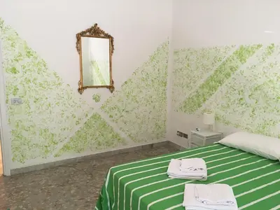 a bedroom with a green and white bed with a mirror at Next Stop Roma Affittacamere Da Florindo in Rome