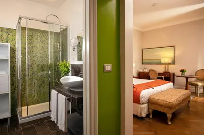 a bedroom with a bed and a bathroom with a sink at Vivaldi Luxury Rooms in Rome