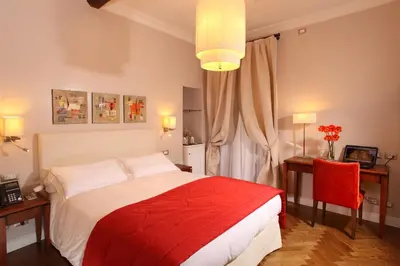 a bedroom with a red and white bed and a window at Vivaldi Luxury Rooms in Rome