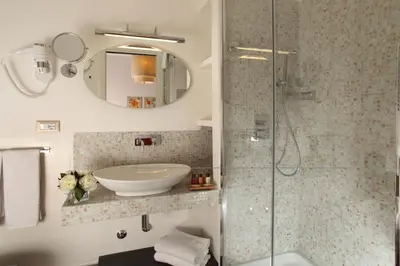 a bathroom with a sink and a glass shower at Vivaldi Luxury Rooms in Rome