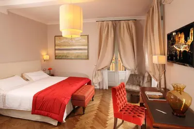 a bedroom with a bed and a table and a chair at Vivaldi Luxury Rooms in Rome