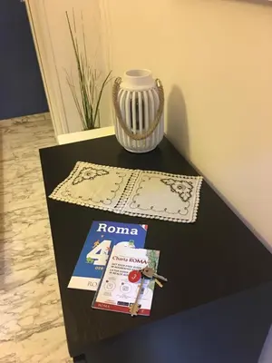 a table with a book and a vase on it at Domum Vaticani in Rome