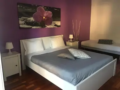 a bedroom with a bed with a purple wall at Domum Vaticani in Rome