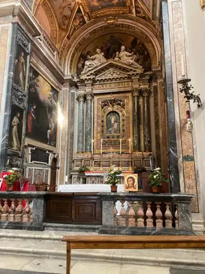 a altar in a church with paintings and a bench at Domum Vaticani in Rome
