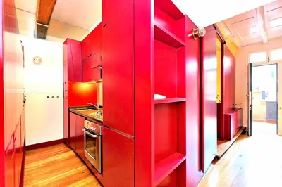 a red kitchen with red cabinets in a room at delCINQUE 26 - Loft in Trastevere in Rome