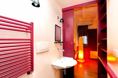 a bathroom with a white sink and a red wall at delCINQUE 26 - Loft in Trastevere in Rome