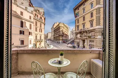 a table and chairs on a balcony with a street at Cavour Colloseum suite in Rome