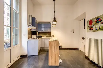 a kitchen with white cabinets and a table in a room at Cavour Colloseum suite in Rome