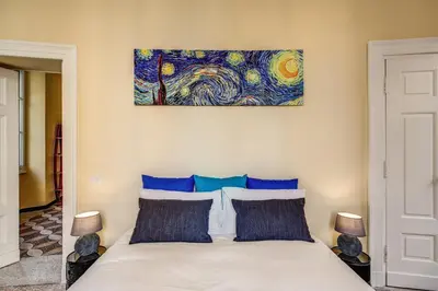 a bedroom with a bed with a painting on the wall at Cavour Colloseum suite in Rome