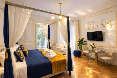 a bedroom with a canopy bed and a living room at Suites Piazza Del Popolo in Rome