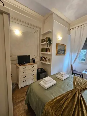 a bedroom with a large bed and a desk at Suites Piazza Del Popolo in Rome