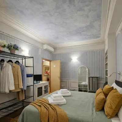 a bedroom with a bed and a dresser with towels on it at Suites Piazza Del Popolo in Rome