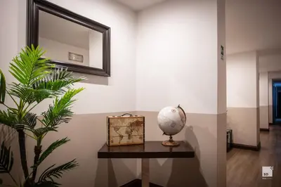 a mirror on a wall next to a table with a plant at Hotel Boutique Nazionale in Rome