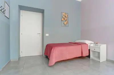 a bedroom with a bed and a couch and a chair at Holiday Sunny Roma B&B in Rome