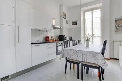 a kitchen with white cabinets and a table and chairs at Holiday Sunny Roma B&B in Rome