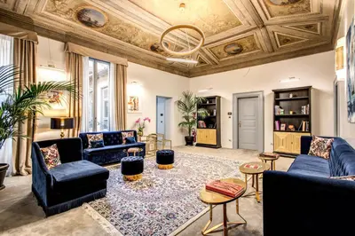 a living room with blue furniture and a coffered ceiling at Martius Private Suites Hotel in Rome