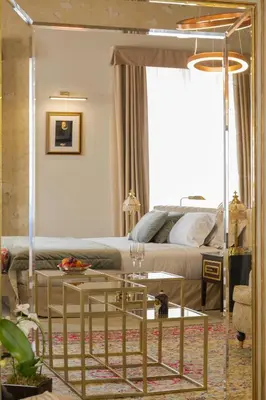 a bedroom with a bed and a table and a mirror at Martius Private Suites Hotel in Rome