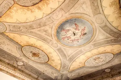 a ceiling in a building with a painting on it at Martius Private Suites Hotel in Rome