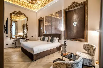 a hotel room with a bed and a chair at Martius Private Suites Hotel in Rome