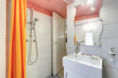 a bathroom with an orange shower curtain and a sink at Il Nido in Rome