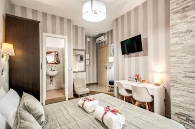 a hotel room with a bed and a dining room at Santamaggiore in Rome