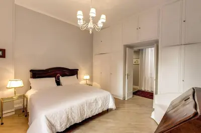 a bedroom with a large white bed and a chandelier at Lovely Flat by the Vatican in Rome