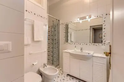 a bathroom with a sink and a toilet and a mirror at Lovely Flat by the Vatican in Rome