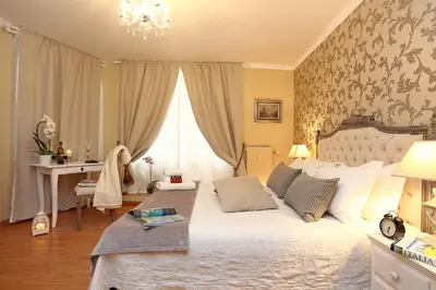 a bedroom with a large white bed and a desk at Liberty Vatican Suites - Liberty Collection in Rome