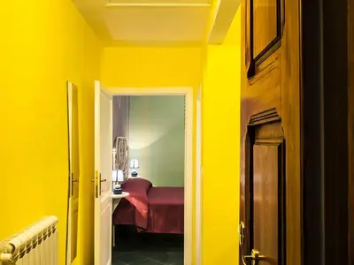 a room with yellow walls and a room with a bed at Rome Best Rent in Rome