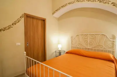 a bedroom with a bed with an orange bedspread at Rome Best Rent in Rome