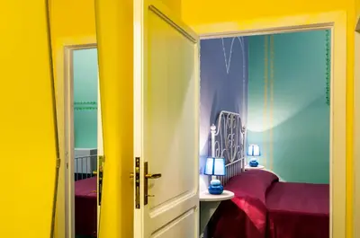 a room with yellow walls and a bedroom with a bed at Rome Best Rent in Rome