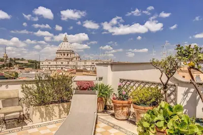 a bench on a balcony with a view of the capitol building at Attic with Terrace Overlooking St Peter's Basilica in Rome
