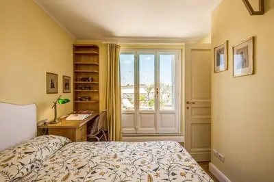 a bedroom with a bed and a desk and a window at Attic with Terrace Overlooking St Peter's Basilica in Rome