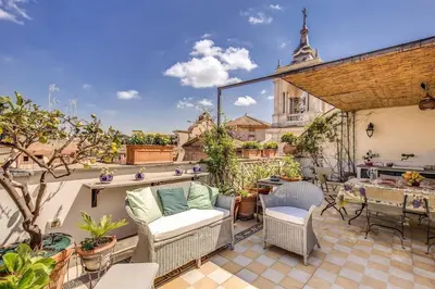 a patio with a couch and chairs on a roof at Attic with Terrace Overlooking St Peter's Basilica in Rome