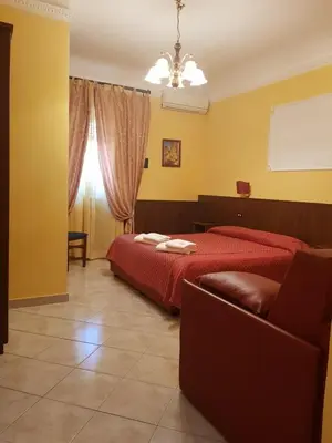 a bedroom with a red bed and a couch at B&B Rudy in Rome