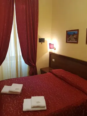 a bedroom with a red bed with two towels on it at B&B Rudy in Rome