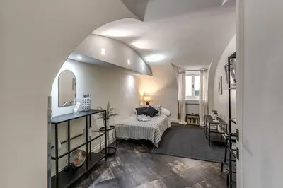 a living room with a bed and a mirror at Fori Imperiali Apartment in Rome