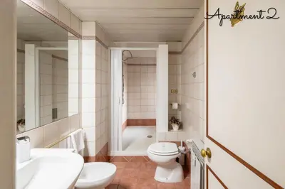 a bathroom with a toilet and a sink and a tub at PennyLane Rome Apartment in Rome