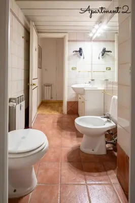 a bathroom with two toilets and a sink at PennyLane Rome Apartment in Rome